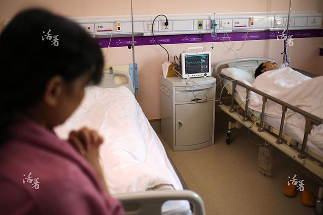 Nhìn vào khuôn mặt được băng kín của con trên giường, mẹ Ting Liu không biết làm gì hơn là ngồi cầu nguyện.

