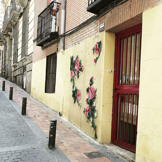 Hoa văn hình hoa hồng thêu được gắn trên tường nhà ngoài phố tạo điểm nhấn trong thiết kế.
