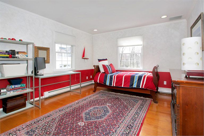 Một phòng ngủ khác được trang trí với gam màu nóng đơn giản. Giá để đồ và tủ được kê sát tường để mở ra không gian giữa phòng.
