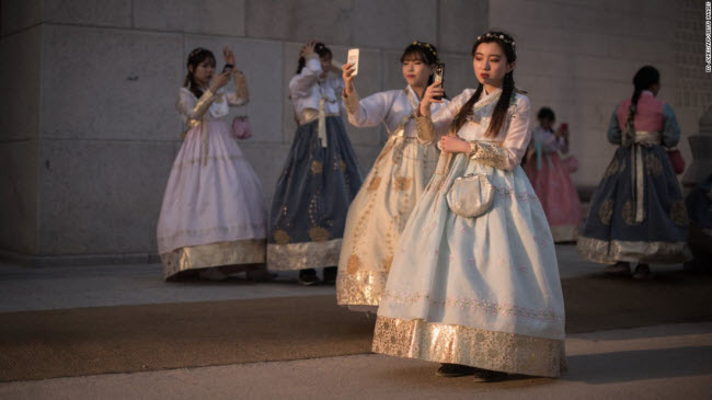 Seoul, Hàn Quốc: Nhóm thiếu nữ Hàn Quốc mặc trang phục hanbok truyền thống chụp ảnh “tự sướng” trước cung điện Gyeongbokgung.
