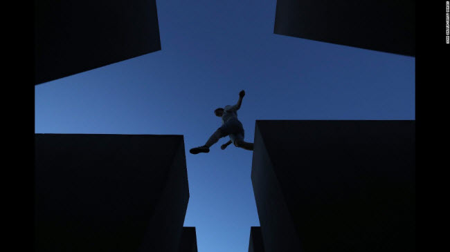 Berlin, Đức: Du khách nhảy các khối bê tông tại đài tưởng niệm Holocaust được thiết kế bởi kiến trúc sư Peter Eisenman và kỹ sư Buro Happold.
