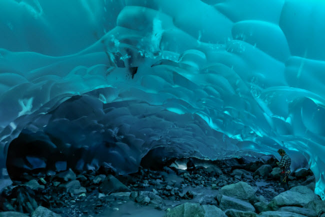 Hang băng Mendenhall, Alaska: Hệ thống hang băng kỳ vĩ này nằm dưới dòng sông băng Mendenhall ở Alaska. Vách hang có màu xanh nhạt, tạo nên không gian kỳ ảo.
