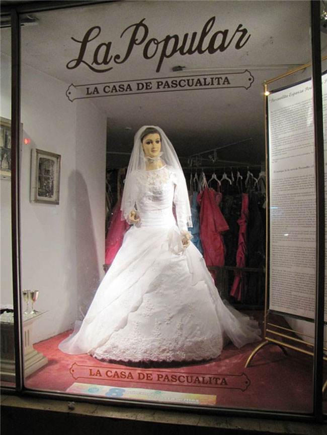 Bức tượng  xác ướp ma-nơ-canh xinh đẹp La Pasqualita

Một tiệm áo cưới ở Chihuahua, Mexico vô cùng nổi tiếng có không chỉ bởi những bộ áo cưới lộng lẫy, kiểu dáng thời thượng đẹp mắt mà còn bởi “cô nàng” ma-nơ-canh La Pascualita. “Cô người mẫu” xinh đẹp, duyên dáng, khuôn mặt rạng rỡ, trên tay luôn cầm bó hồng trắng.
