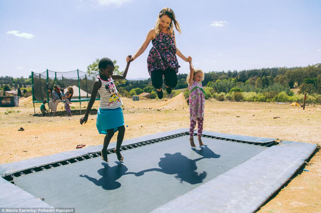 Cô gái trẻ chơi đùa với trẻ em địa phương trong hành trình tới Nam Phi.
