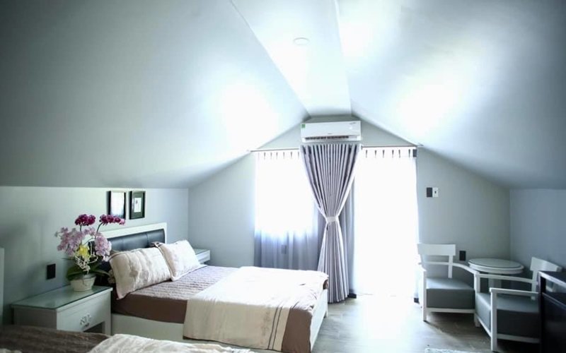 Phòng ngủ ấm cúng, ngập ánh sáng với phần 1 tường được thay bằng kính.
