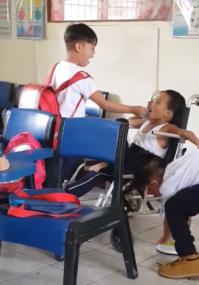 Hình ảnh xúc động: Hai bé trai tận tình chăm sóc bạn học bị bại não dù không ai bảo - 1