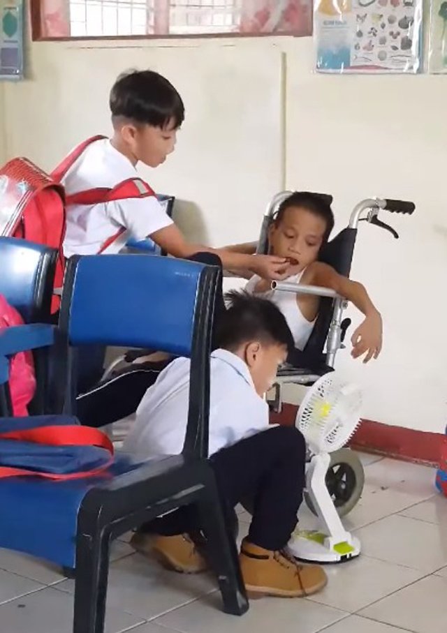 Hình ảnh xúc động: Hai bé trai tận tình chăm sóc bạn học bị bại não dù không ai bảo - 2