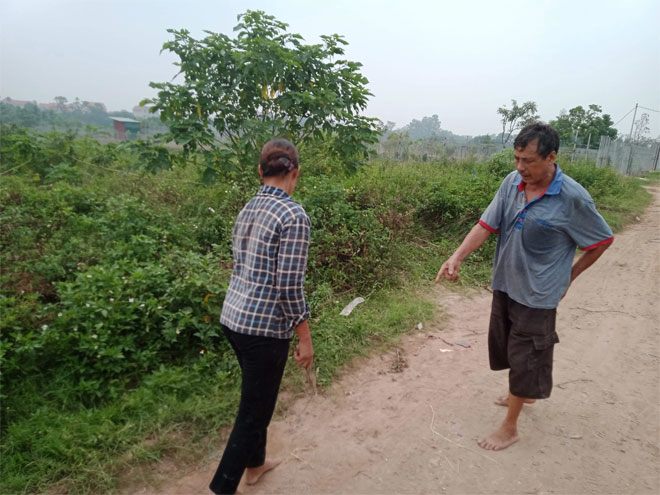 Ông Đỗ Sỹ Thục (áo xanh) chỉ nơi phát hiện thi thể chị H, cách nhà khoảng vài trăm mét.