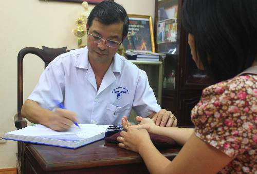 Lương y Phó Hữu Đức xem mạch và tư vấn cho bệnh nhân nữ.