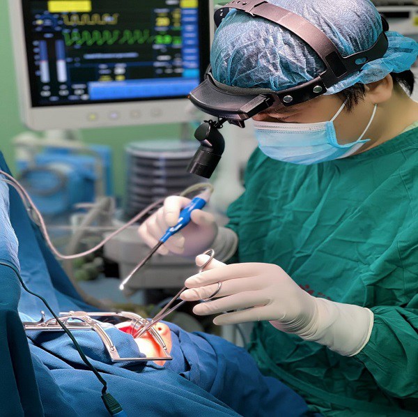 Bác sĩ đang tiến hành phẫu thuật cho bé trai bị viêm amidan quá phát.