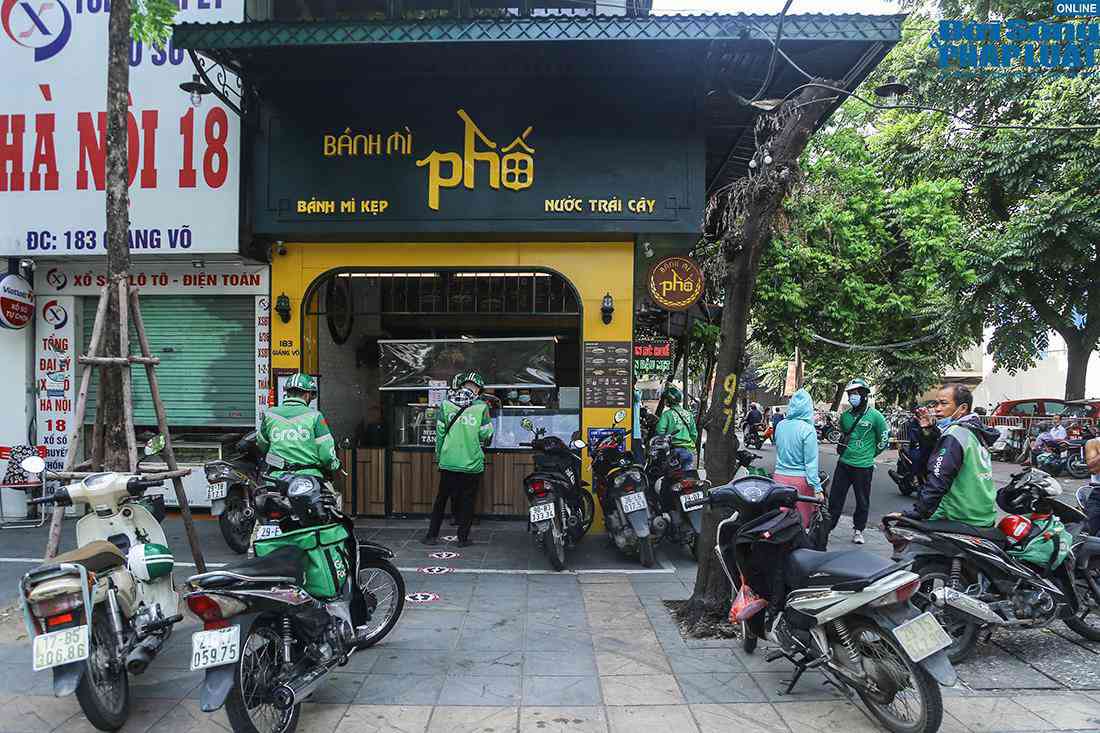 Tại một cửa hàng bánh mỳ trên phố Giảng Võ, chủ cơ sở kinh doanh đã trang bị tấm chắn giọt bắn ngăn cách, đồng thời liên tục nhắc nhở các shipper đứng giãn cách, không tụ tập thành nhóm