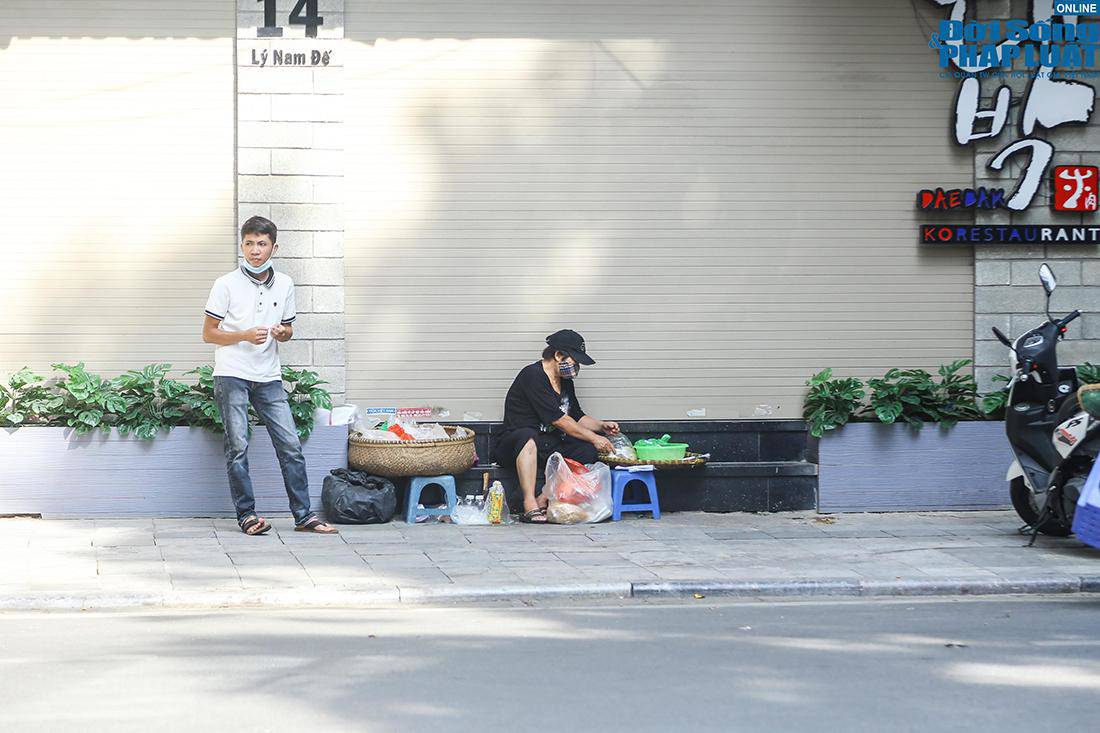 Một gánh hàng rong bày bán ngay trên vỉa hè phố Lý Nam Đế (quận Hoàn Kiếm, Hà Nội)