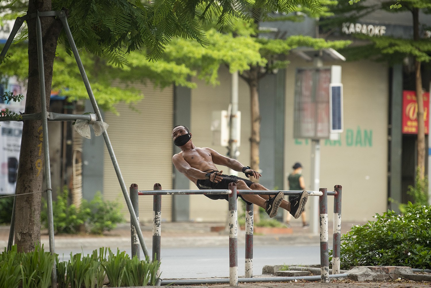 Một người đàn ông tận dụng rào chắn trên đường Kim Liên mới để làm dụng cụ tập thể dục buổi sáng.