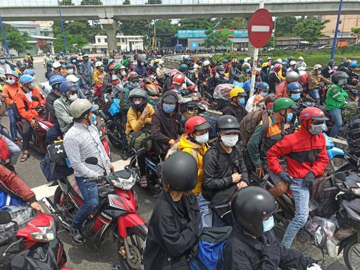 Hàng trăm người lỉnh kỉnh đồ đạc, ôm con nhỏ... để về quê tránh dịch.
