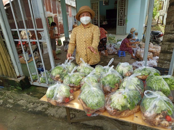Bà cùng người dân trong xóm đóng gói từng bịch thực phẩm.