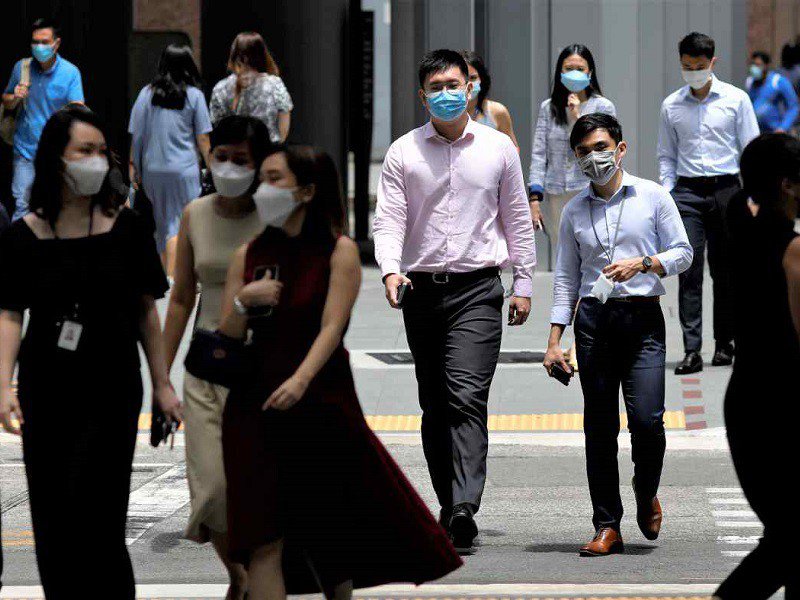 Người dân Singapore duy trì việc đeo khẩu trang và dần khôi phục cuộc sống thường nhật khi nước này chọn sống chung với COVID-19. Ảnh: REUTERS