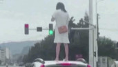 Giận chồng, vợ trèo lên nóc xe đứng