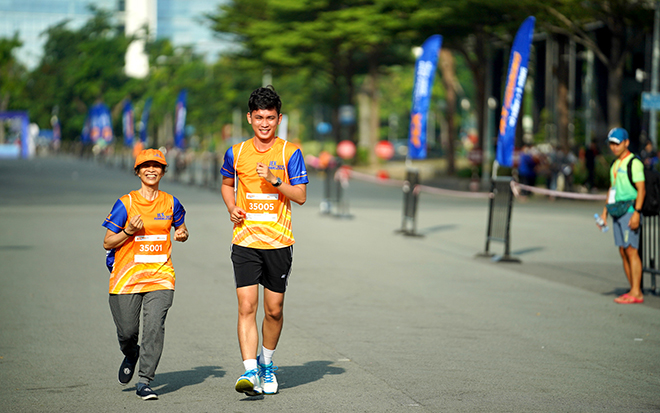 Cô Vinh hứng khởi tham gia chạy cùng các vận động viên trẻ