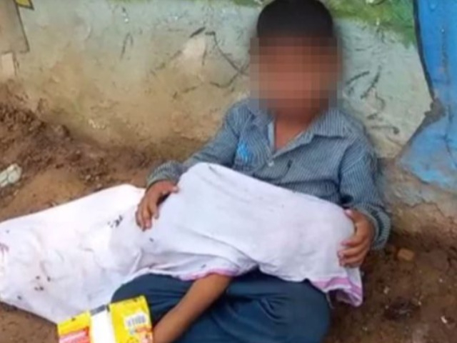 Xót xa bé trai ôm thi thể đứa em ngồi bên đường, vừa khóc vừa đuổi ruồi