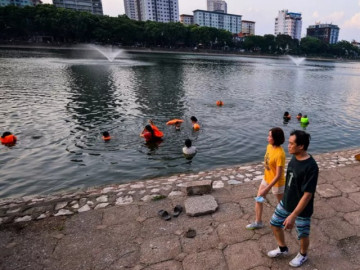 Hồ nước bị vứt rác, đồ thờ cúng ngổn ngang nhưng người dân vẫn vô tư xuống bơi lội