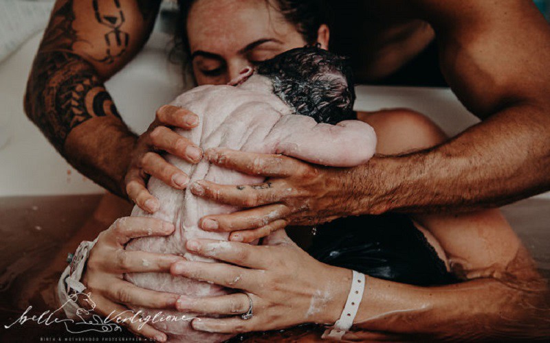 Nhiếp ảnh gia Belle Verdiglione đã có một bức ảnh Con chào đời trong vòng tay cha mẹ vô cùng ấm áp.
