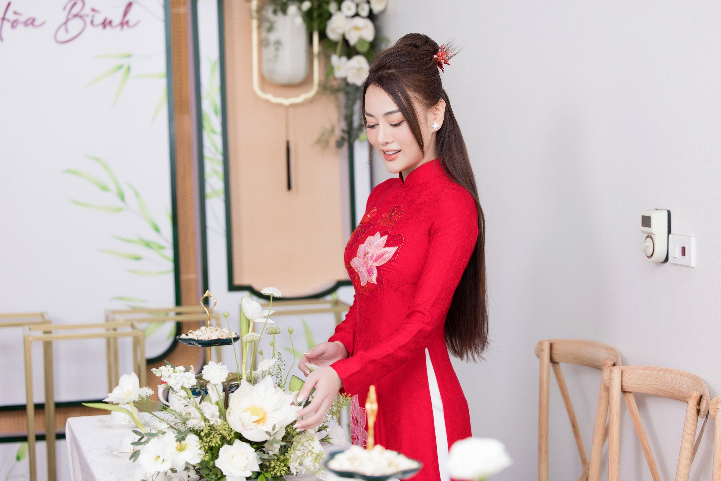 Người đẹp diện áo dài màu đỏ thêu hình hoa sen.