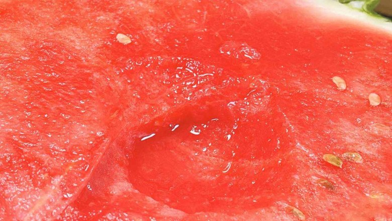 A slice of watermelon being cut