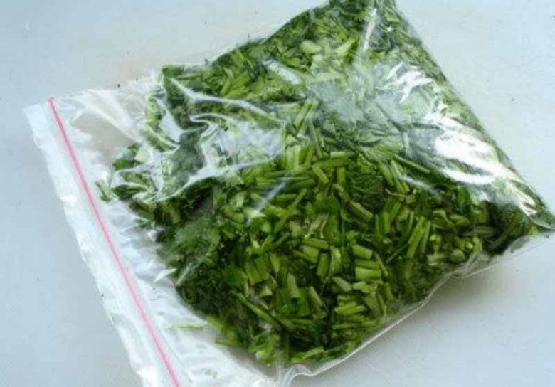 Storing chopped coriander in a ziplock bag in the freezer