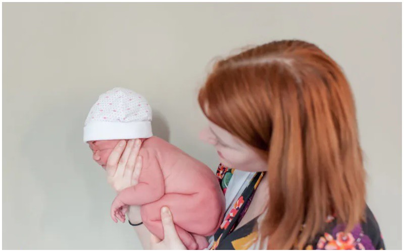 Một em bé sơ sinh mới chào đời được tạo dáng như khi còn là một thai nhi bé bỏng. 
