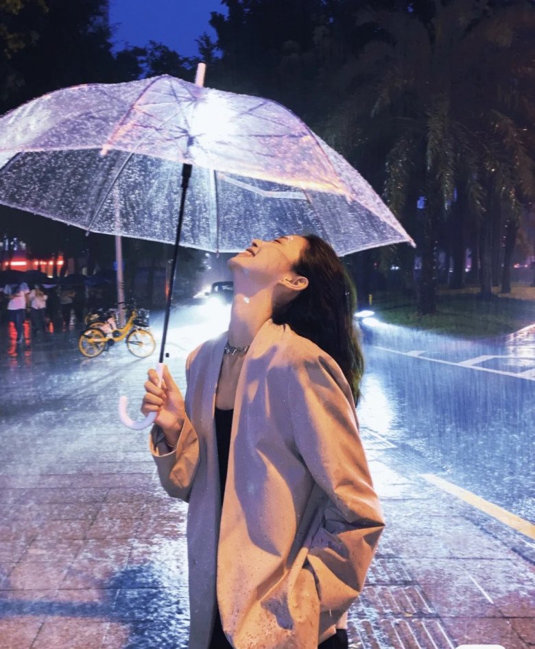 A woman holding an umbrella in the rain, with a focus on editing techniques