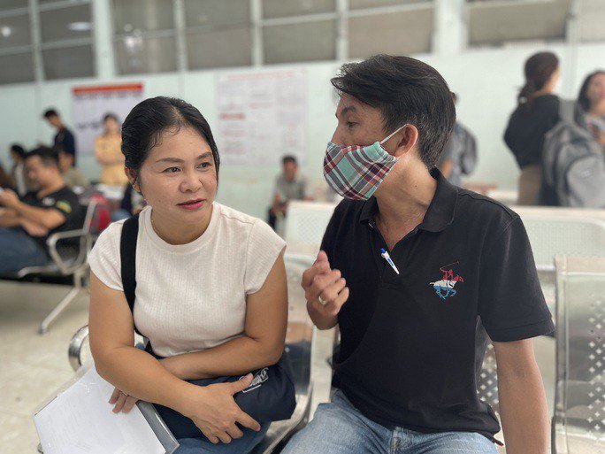 Ông Nguyễn Xương Quân chia sẻ thông tin về Thông tư 24 cho một người khác cùng đến đăng ký xe.