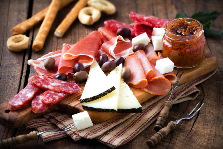 Image of a luxurious table setting with a variety of cold cuts and appetizers