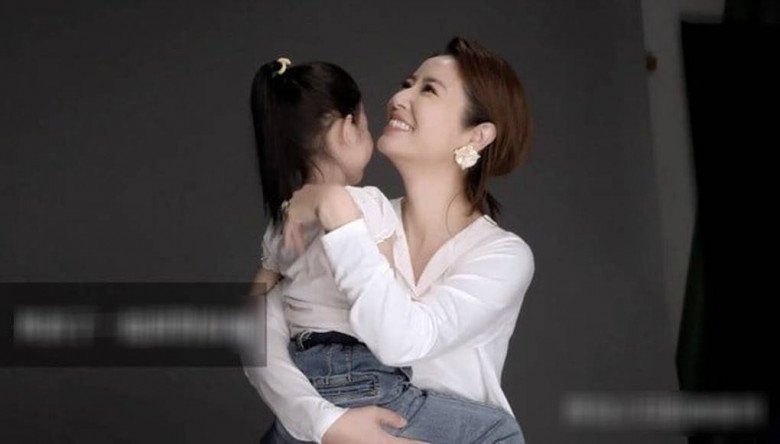 Trong khung hình có màu, có thể thấy Cá Heo Nhỏ sở hữu cặp má phúng phính và nước da trắng ngần, mái tóc dài nữ tính giống mẹ.