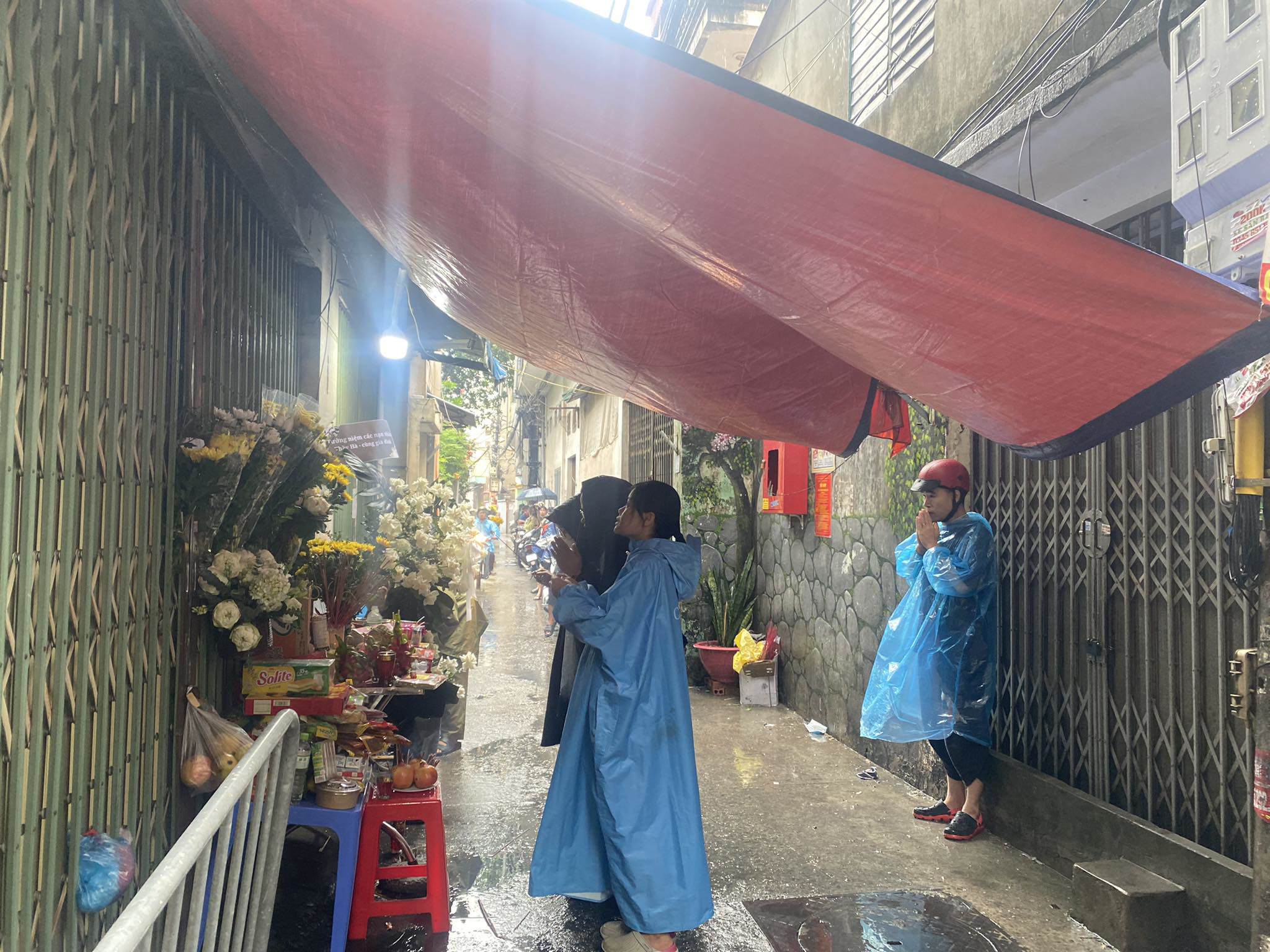 View - Người dân đội mưa đến thắp hương cho nạn nhân vụ cháy chung cư mini