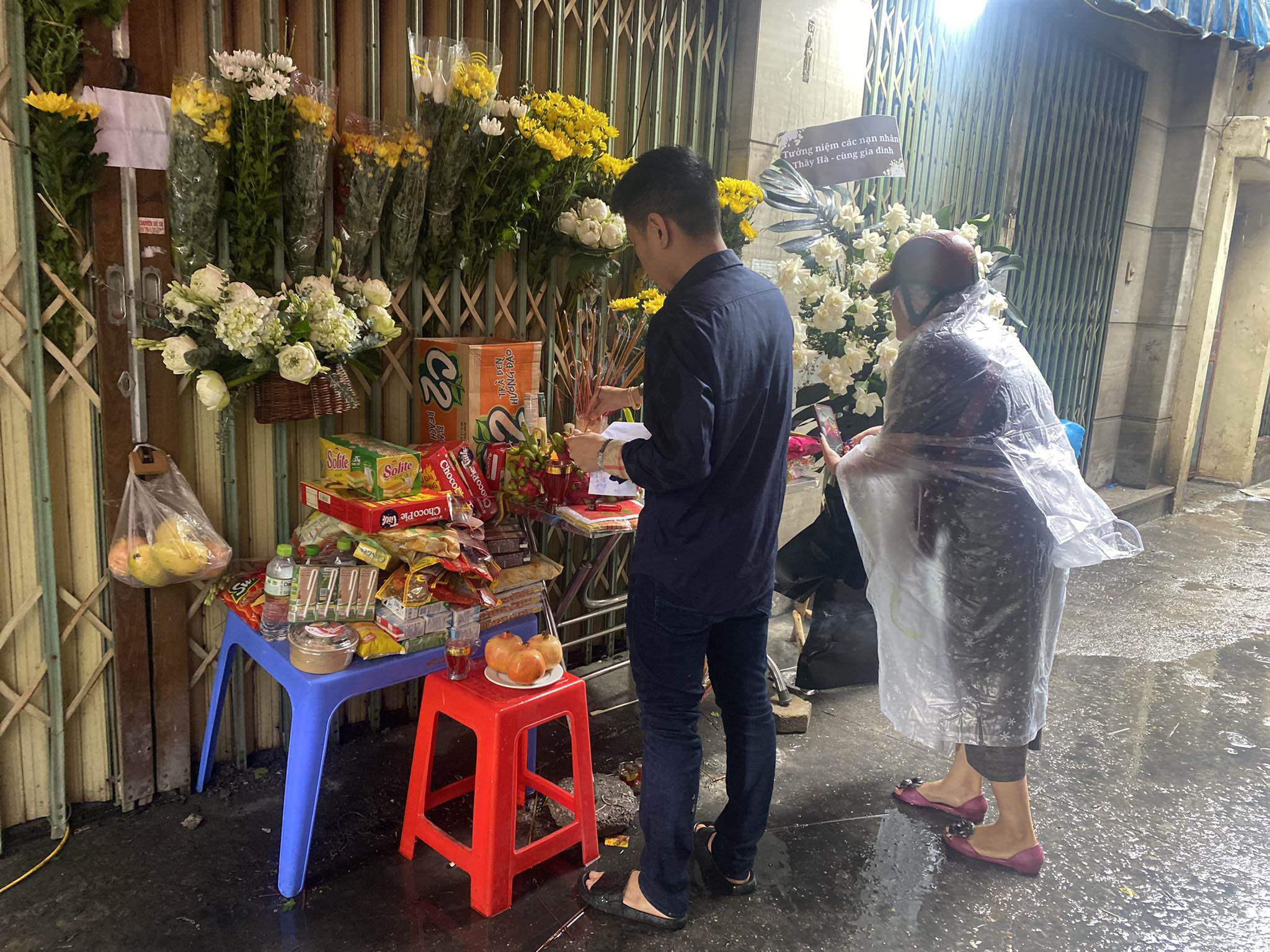 View - Người dân đội mưa đến thắp hương cho nạn nhân vụ cháy chung cư mini