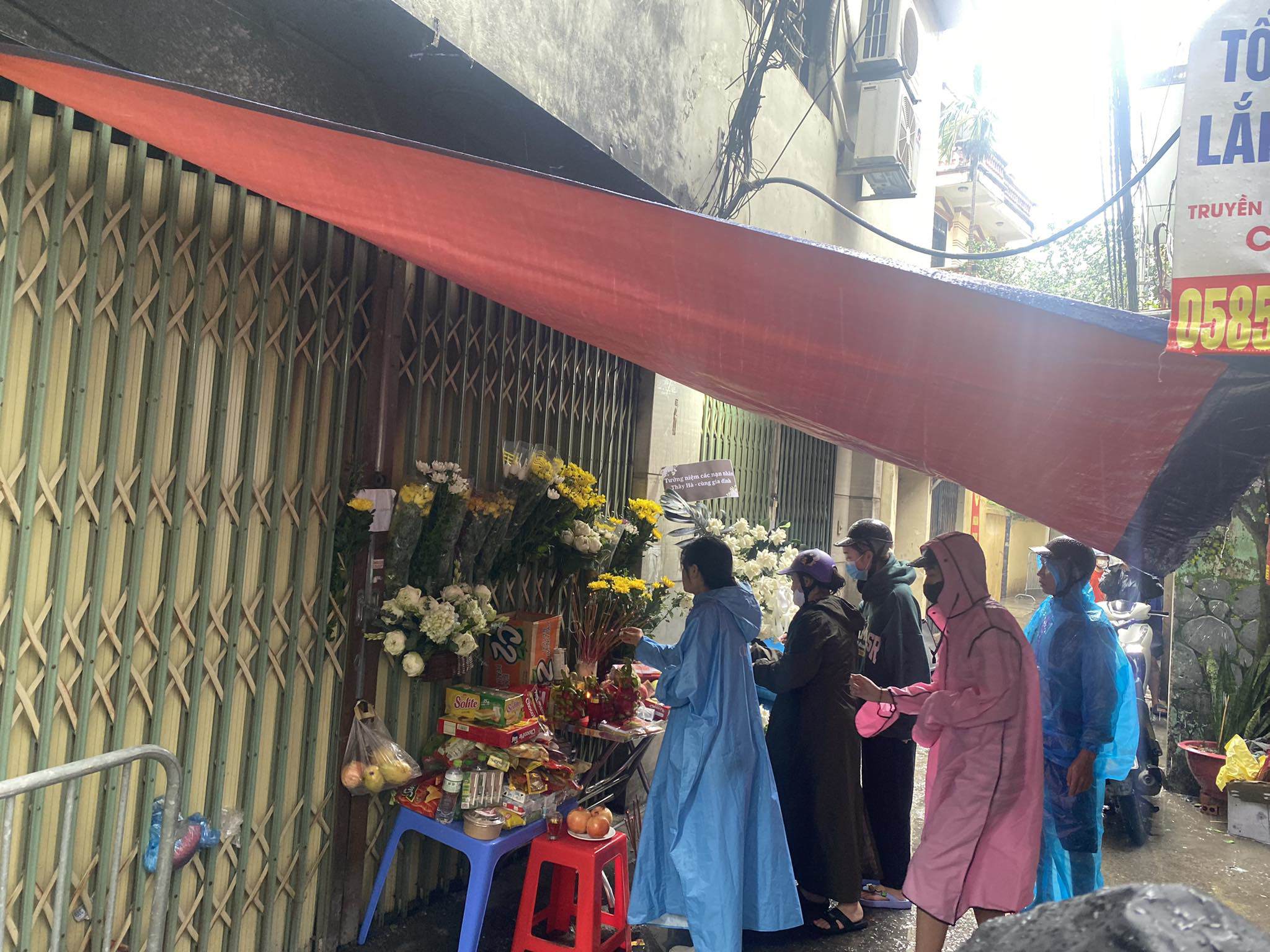 View - Người dân đội mưa đến thắp hương cho nạn nhân vụ cháy chung cư mini