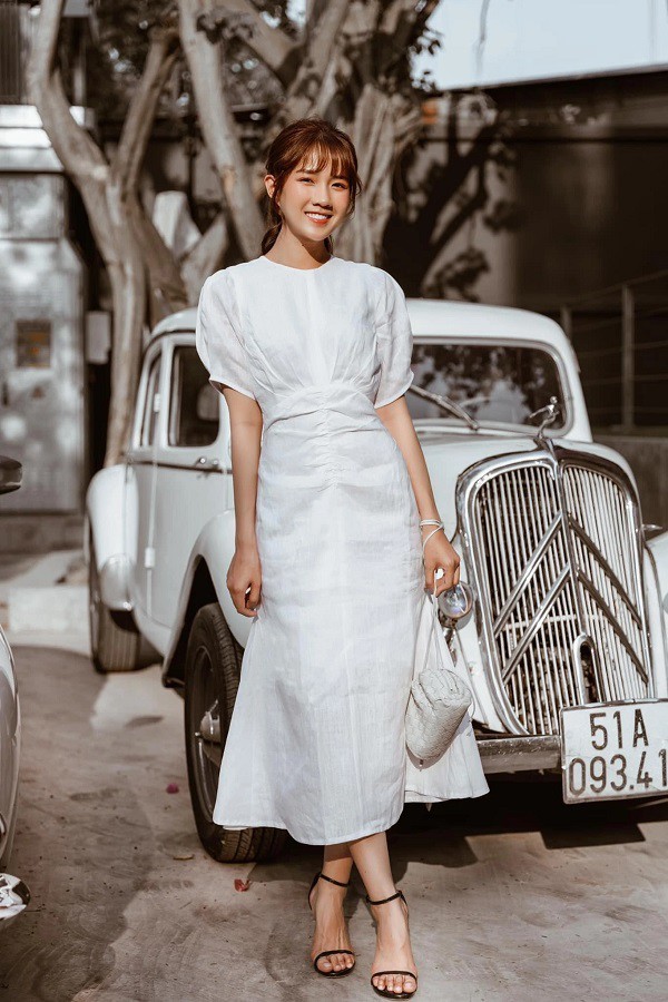 A woman wearing a simple white dress