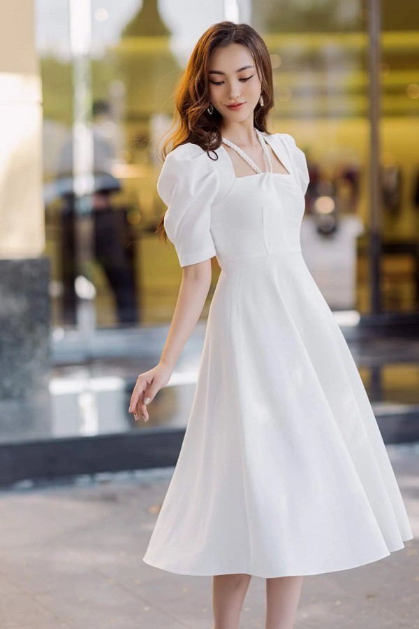 A woman wearing a white puff-sleeved dress