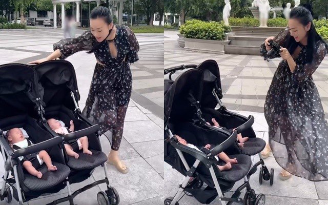 Phương Oanh đẩy 2 con đi dạo chơi.