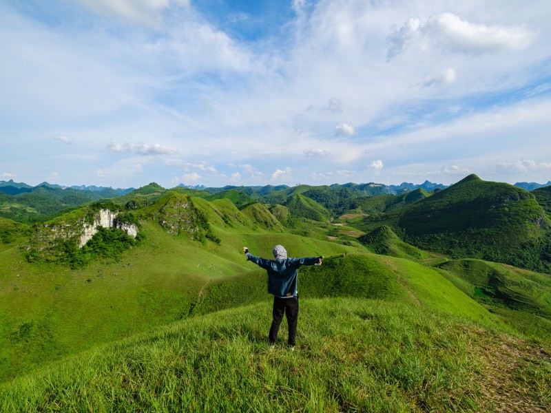 Đứng tại đồi cỏ Ba Quáng, du khách có thể ngắm trọn vẹn khung cảnh thiên nhiên tươi đẹp. Phía trên là bầu trời phủ mây, bên dưới là thảm cỏ xanh trải dài bất tận, phủ kín những quả đồi. (Ảnh: Đàm Anh)
