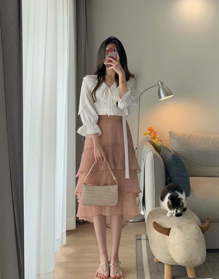 Sự lựa chọn nhẹ nhàng cho những ngày làm việc vất vả nơi công sở chính là áo blouse tay bồng màu trắng và chân váy tầng màu nâu đi cùng sandal. Kiểu áo này kín đáo, lịch sự, là item công sở thích hợp cho hội chị em hướng nội thích bản thân xinh đẹp. 