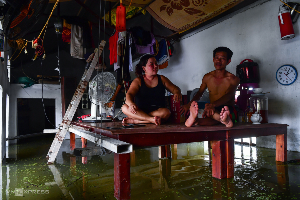 Vợ chồng chị Lê Thị Thành, anh Phạm Văn Đinh ở thôn Nhân Lý vừa nhận được thùng mì tôm do xã hỗ trợ. Nhà tôi cấp 4, khi nước lên cao 1,8 m là anh chị kê hết đồ, giường lên cao, buộc lên mái nhà để vợ chồng ăn uống, sinh hoạt.  Điện bị cắt nên tôi dùng bình ắc quy để sử dụng các thiết bị cơ bản. Thỉnh thoảng tôi chèo thuyền ra ngoài mua đồ, qua nhà hàng xóm nói chuyện cho đỡ buồn, anh Đinh chia sẻ.