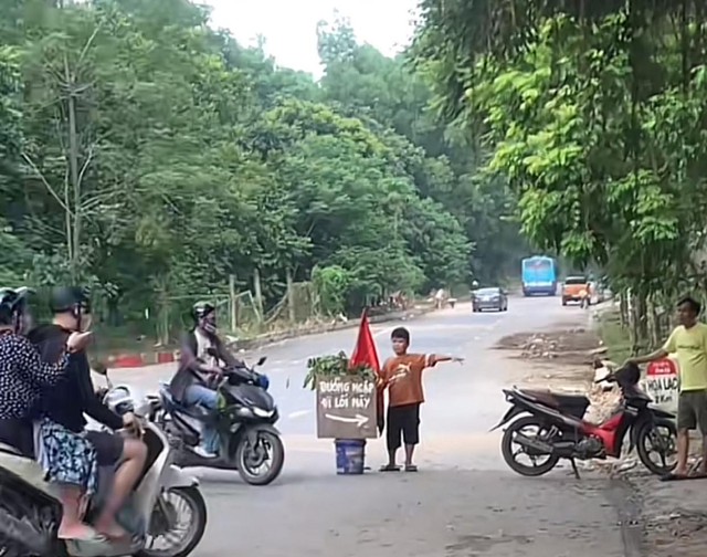 Tấm biển amp;#34;lạamp;#34; giữa làn nước ngập ở đại lộ Thăng Long của 3 chú cháu: Đứng suốt 5 tiếng không thấy mỏi chân - 1