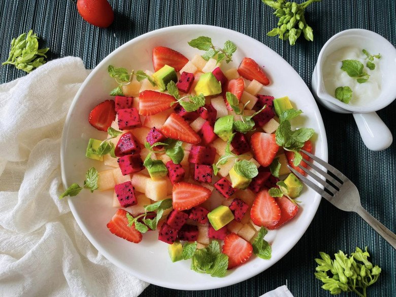 Món salad này gồm: Dâu tây, thanh long, dưa vàng, bơ ăn kèm ít lá  bạc hà, sốt sữa chua.