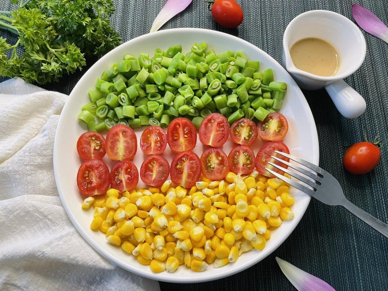 Salad cà chua bi, ngô, đậu cô ve. Ăn kèm sốt mè rang.