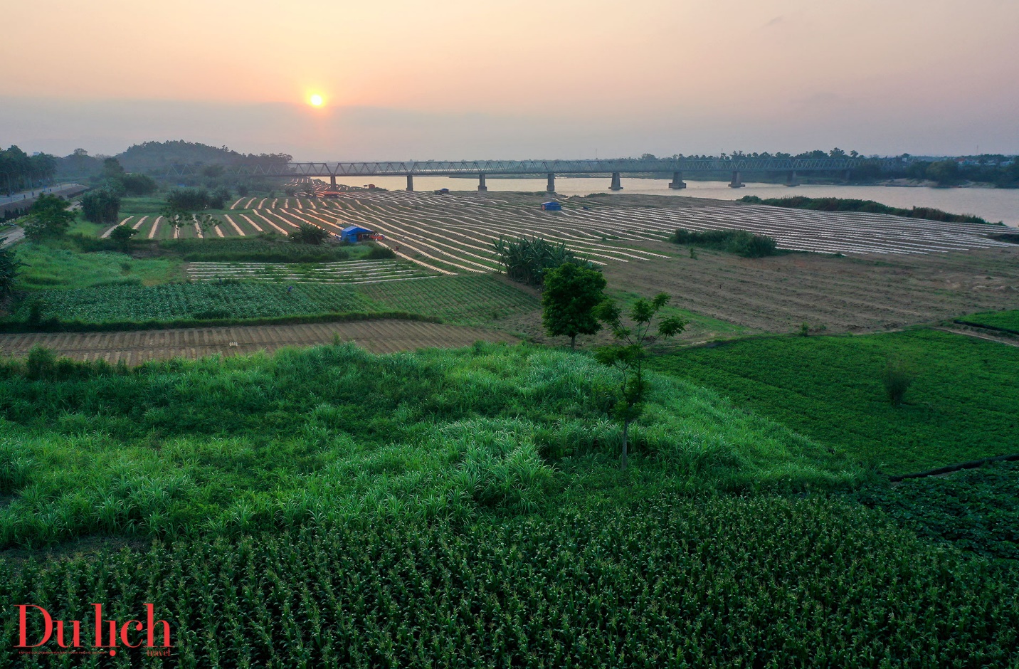 Scenic view of a river with mountains and fields in the background