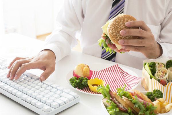 Khi vừa ăn sáng vừa làm việc sẽ khiến não bị phân tâm, không chỉ huy tốt hoạt động ở hệ tiêu hóa. Ảnh minh họa. 