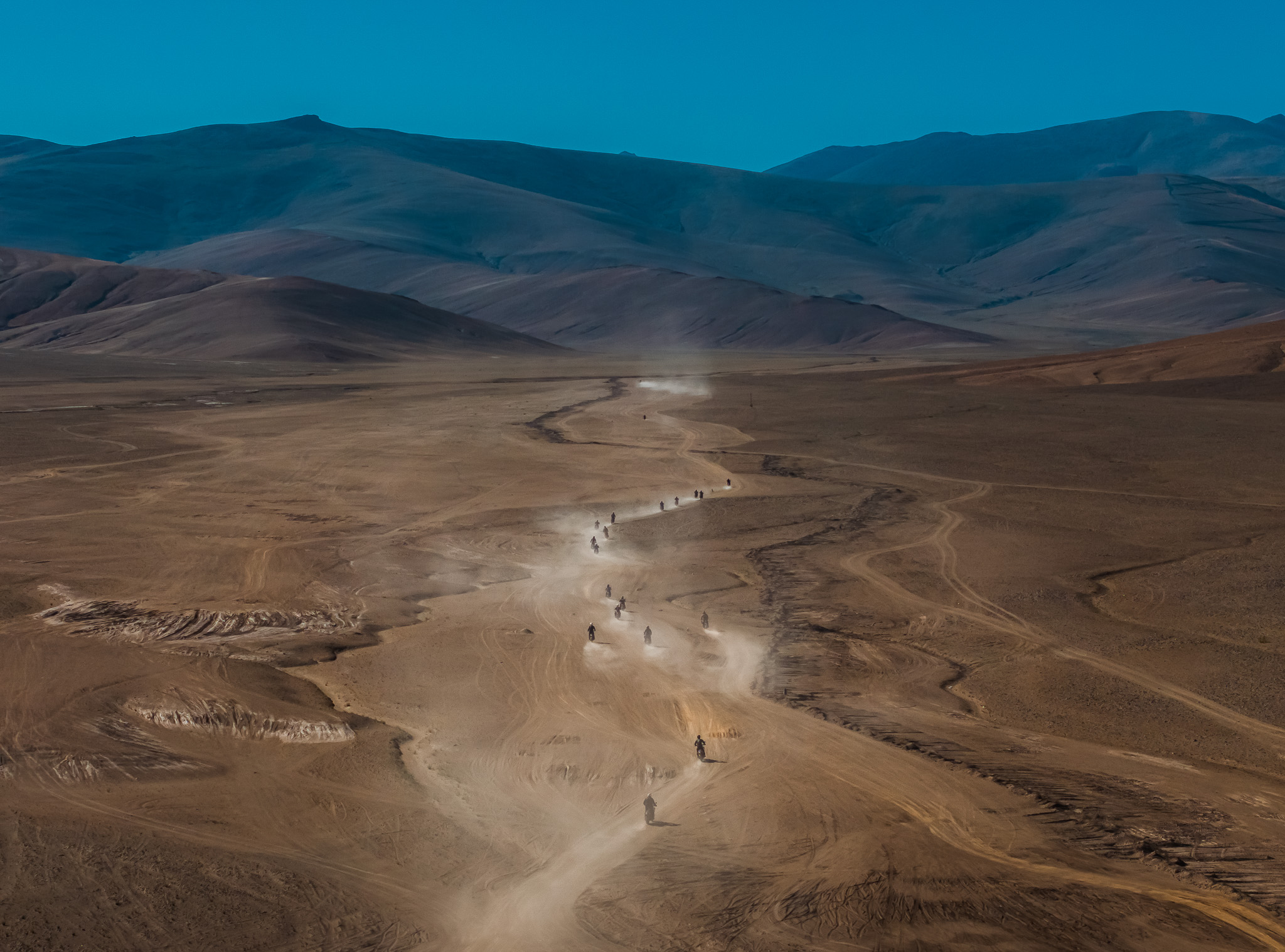 A motorcycle rider navigates a challenging section of the road to Umling La