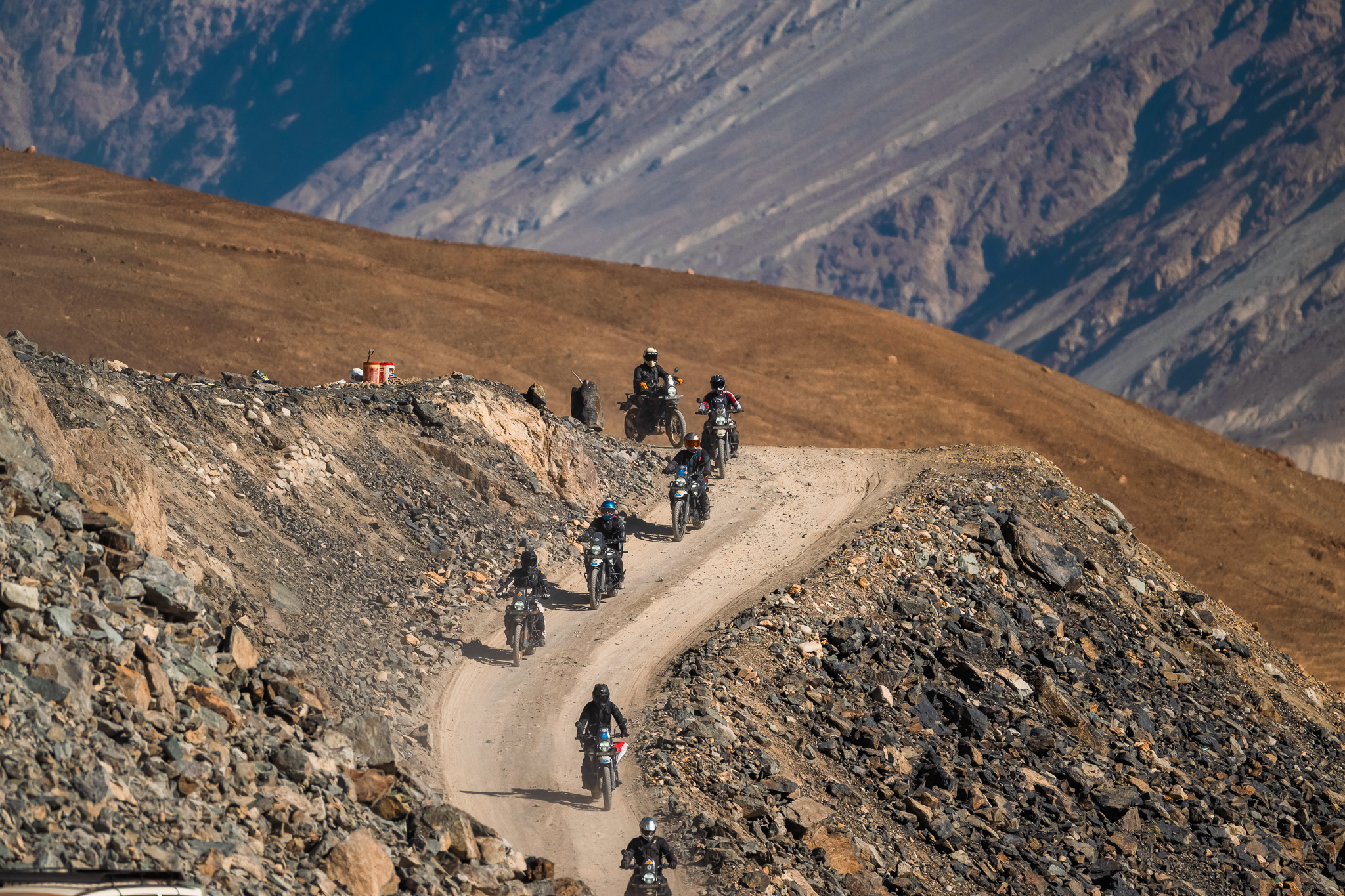 A dangerous section of the road with a sheer drop on one side and a mountain face on the other