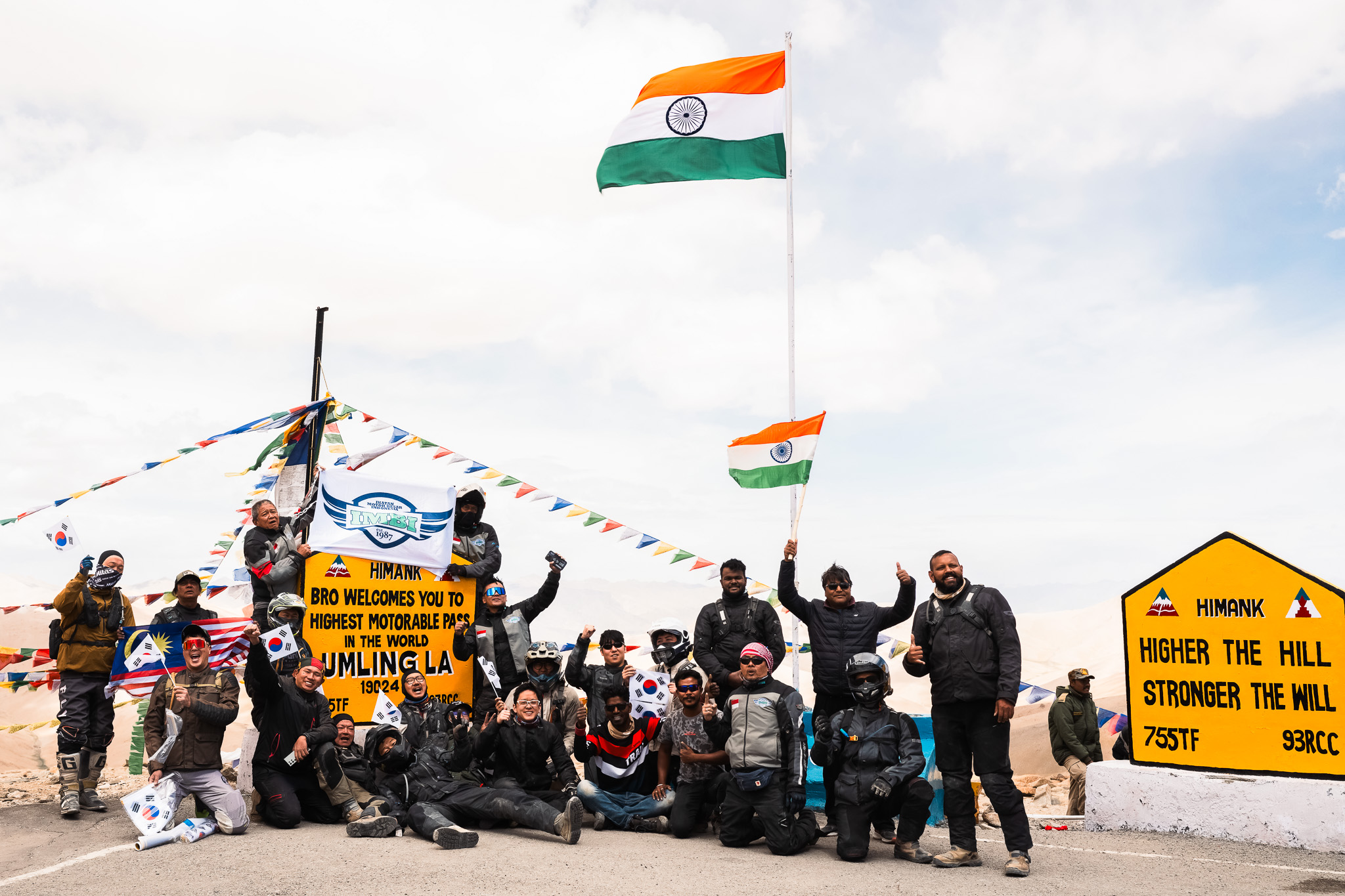 A group of motorcycle riders celebrate their successful ascent to Umling La